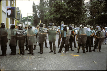 Riot police face off against a group of demonstrators. Injured former combatants of the Farabundo Marti Front for National Liberation (FMLN) and injured Army soldiers joined forces to demand support from the government. San Salvador, El Salvador, 1993
