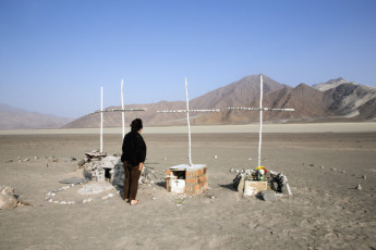 On the side of the Pan-American Highway, Otilia León Velásquez, the sister of Gilmar Ramiro León, looks at the crosses that mark the spot where, in 2011, the remains of Gilmar and the other eight men were found and exhumed in 2011. Huanca Corral, Santa, 2013