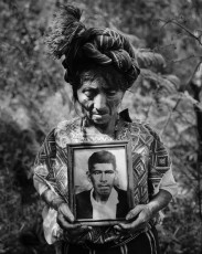 Clara holds a photograph of her husband whose remains are being unearthed. He was fifty years old when soldiers shot him in 1982. Nebaj, 2000