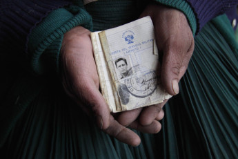 Juana Crisante de Méndez holds the military service ID that belonged to her husband, Fortunato Méndez Huamancusi. Fortunato was detained and then disappeared from the Canaria military base near Hualla in 1984. Ayacucho Region, 2009